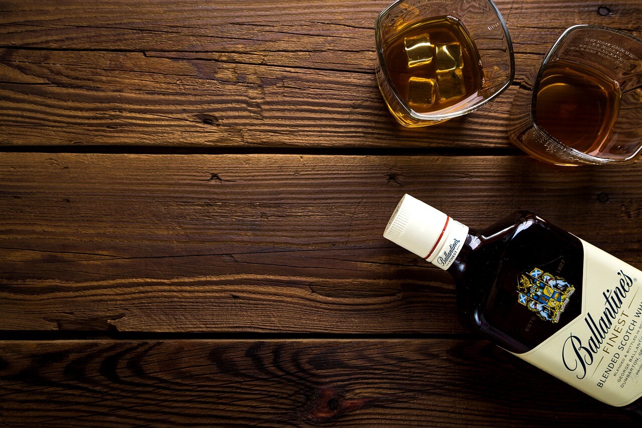 Alcohol bottle and glasses on wooden table