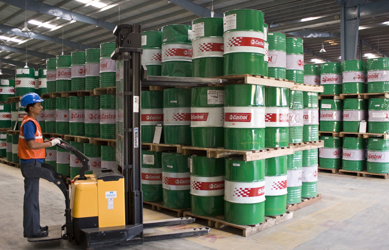 Worker placing drums in a warehouse