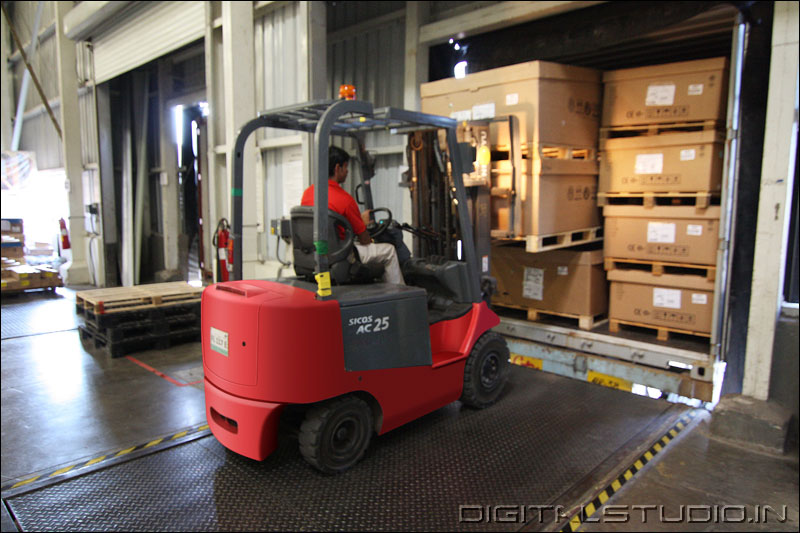 photograph of a worker in a red forklift