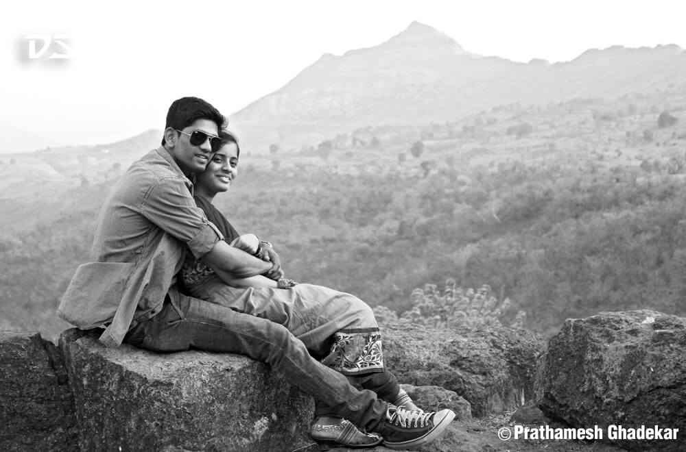 black white couple pose on mountain