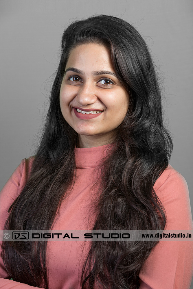 Smiling young lady executive on grey backdrop