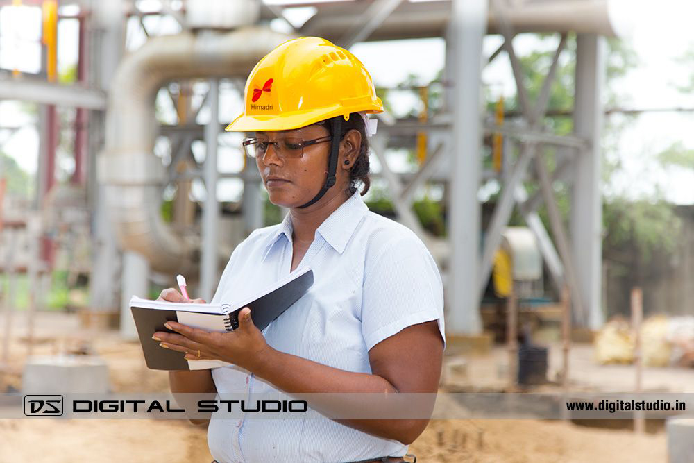Lady engineer making notes in factory