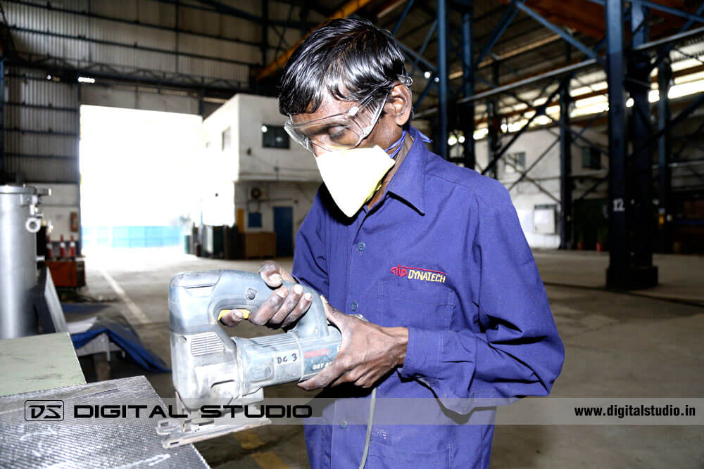 Worker with lathe machine cutting an iron sheet