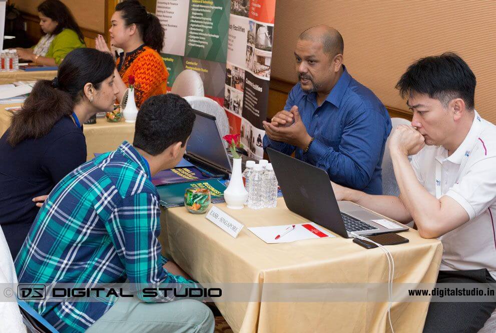 Students at education fair meeting counselors 