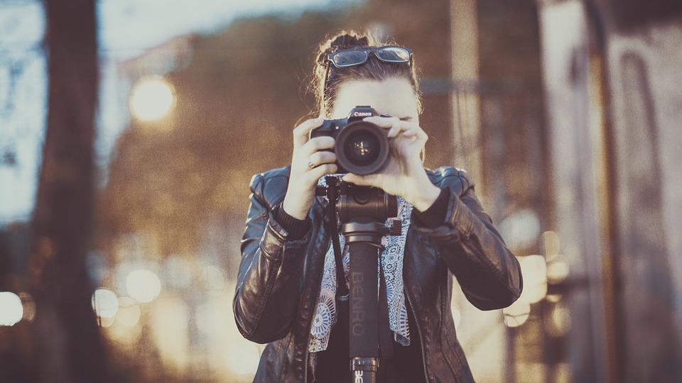 Woman shooting with video camera on tripod