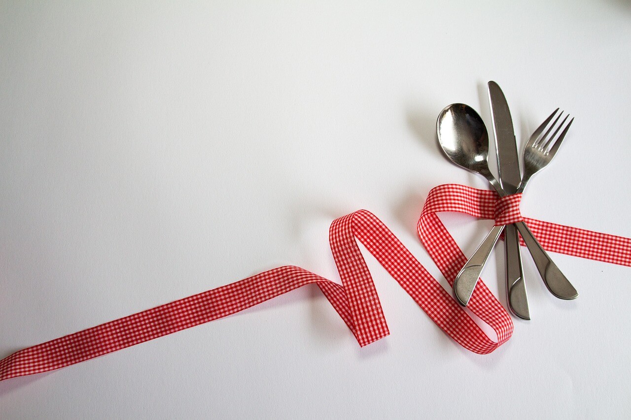 Creative photograph of cutlery and red ribbon