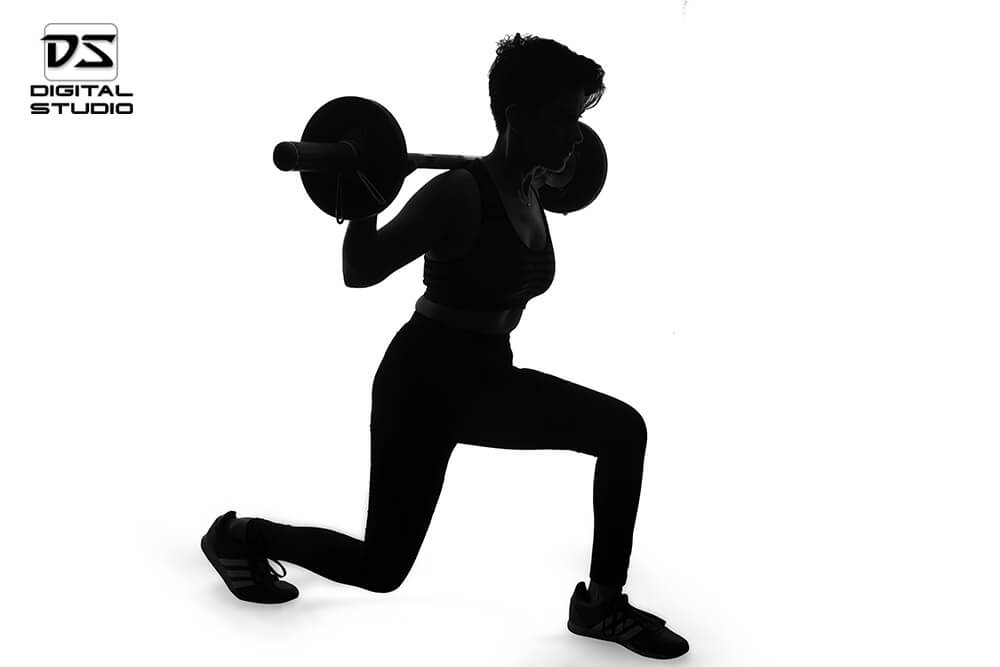 female fitness model doing barbell lunges