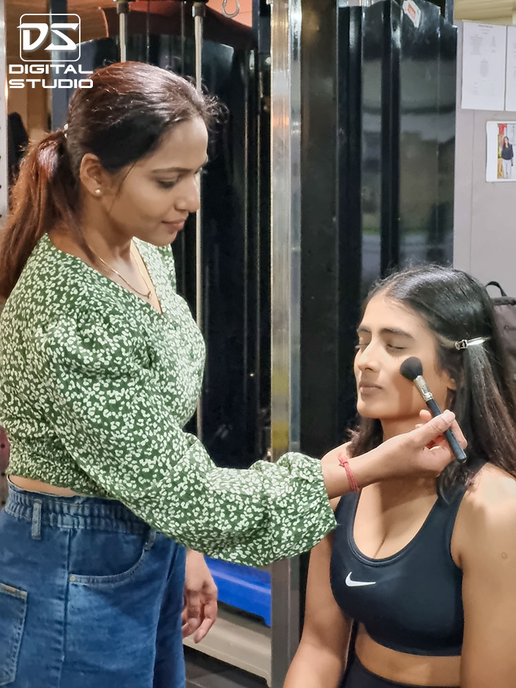 A makeup artist working on the fitness model