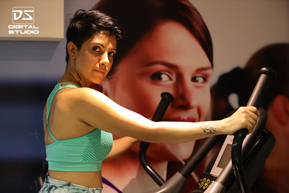 Female bodybuilder on an elliptical machine