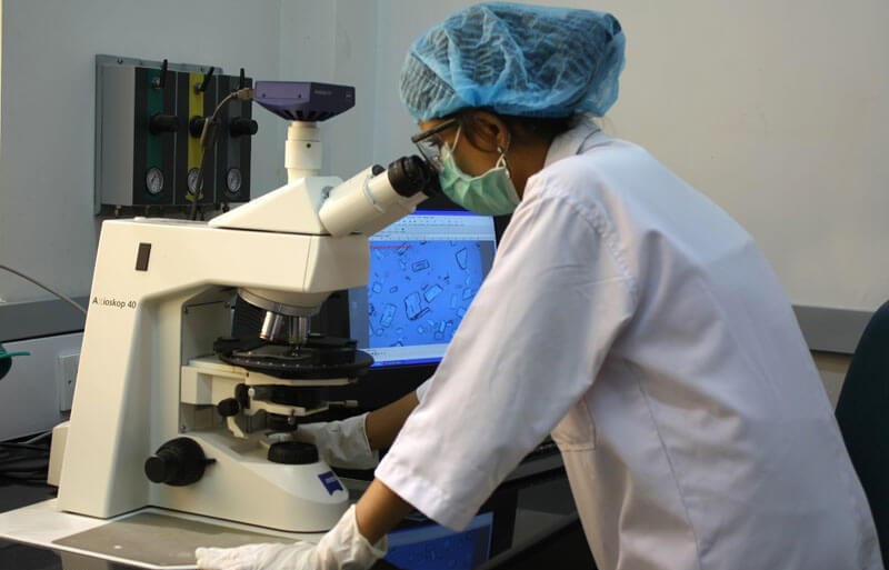 Lab technician working on a microscope