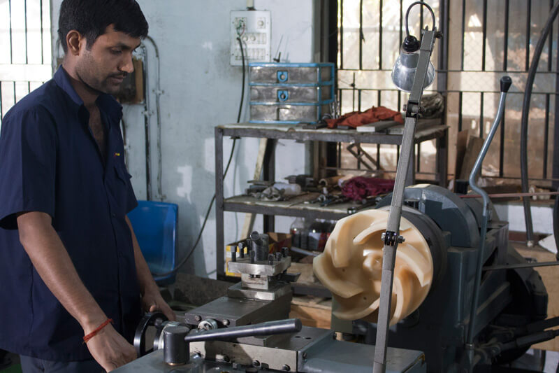 Worker working on a pump making machine