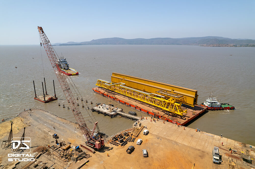 Wide angle view of jetty with crane and loaded barge