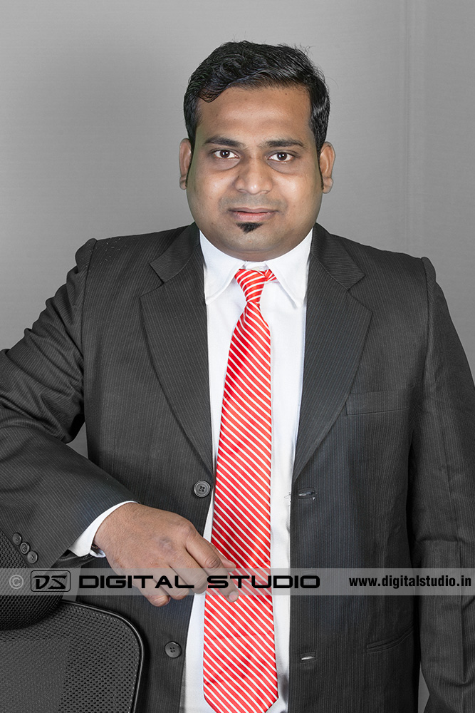Male executive posing on grey backdrop