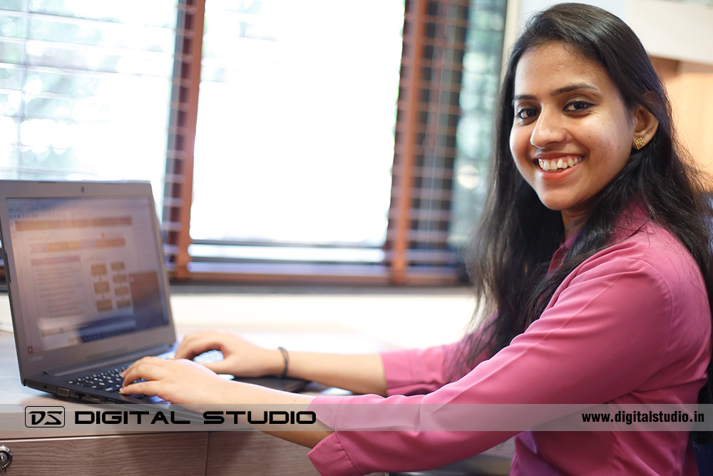 Smiling lady executive working on laptop