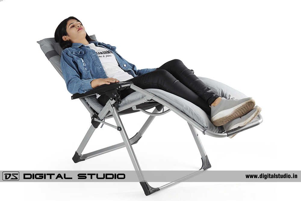 Model relaxing on a garden reclining chair