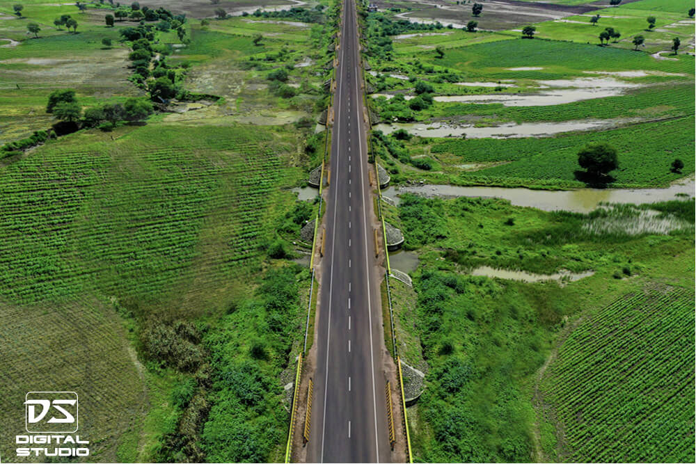 Drone documentation photograph of a highway corridor passing through agricultural green terrain