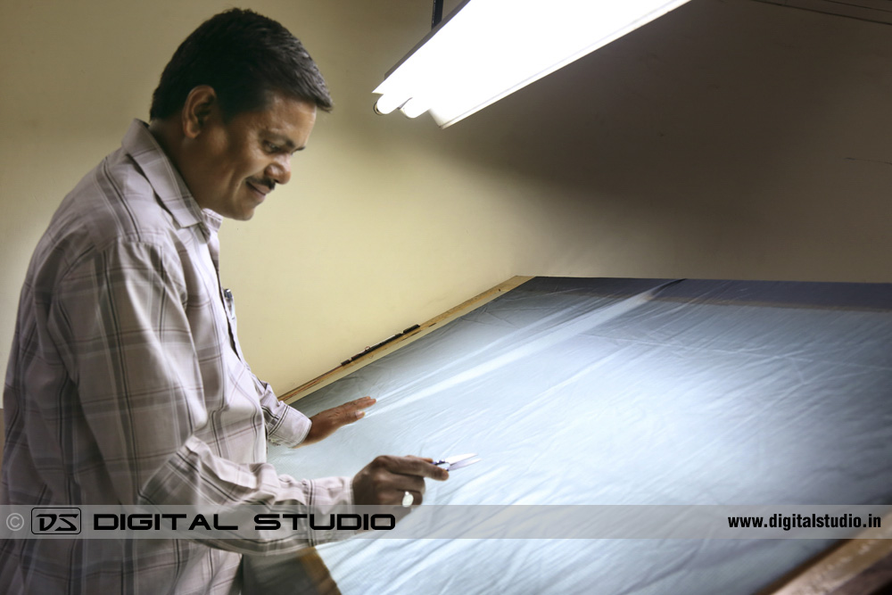 Glass table with worker checking fabric quality