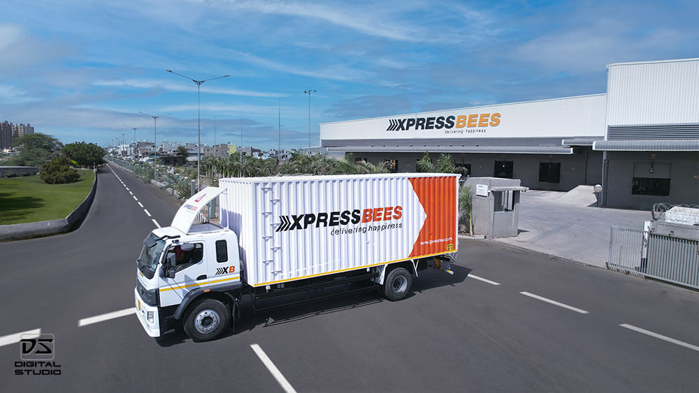 Branded logistics truck at Busybees sorting center for courier pickup and delivery operations
