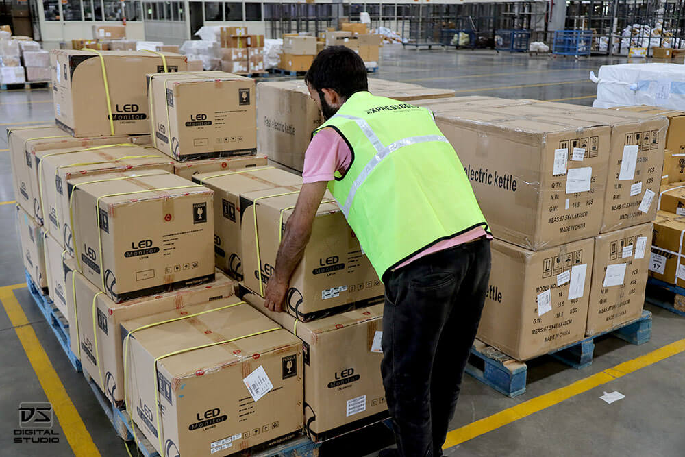 Warehouse staff arranging courier boxes for sorting, scanning, and dispatch workflow