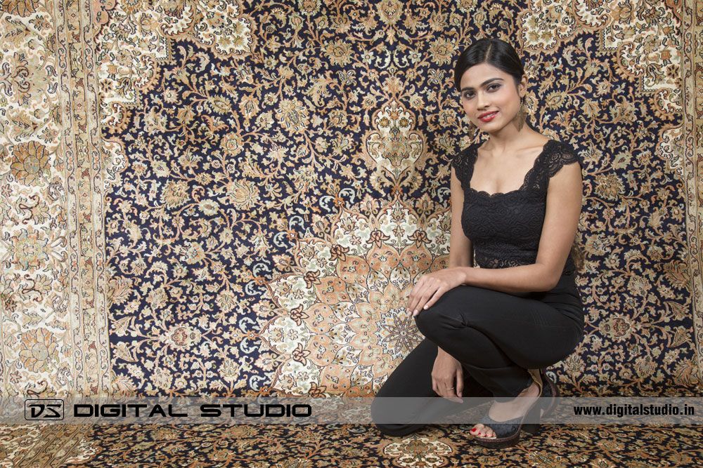 Model posing on a silk oriental rug