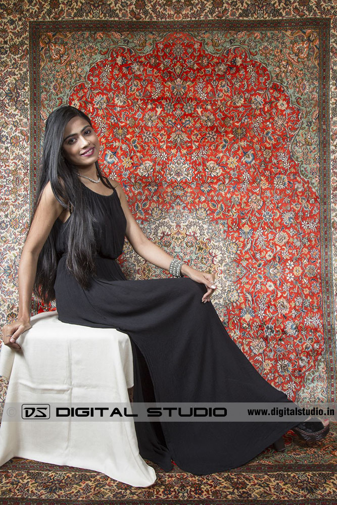 Model sitting on stool with handmade rug