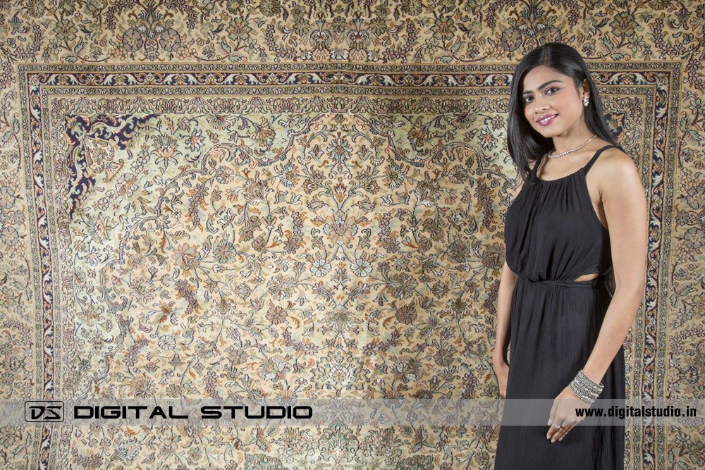 Model with black dress posing with a silk rug