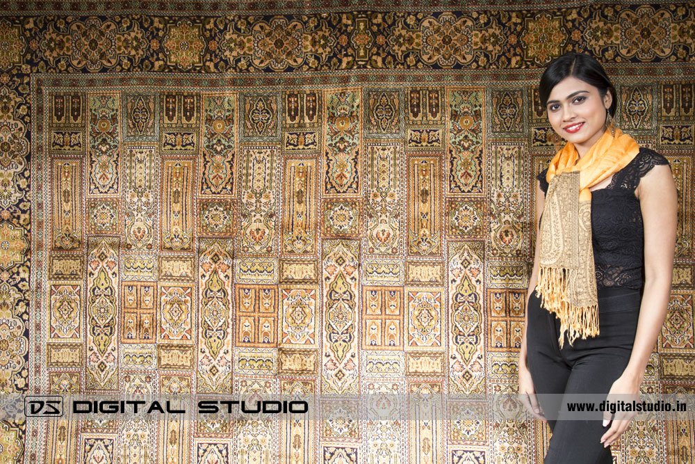 Model wearing a Pashmina along with kashmir carpet