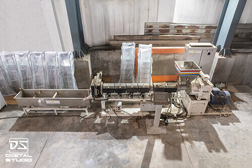 Manufacturing process photography of an industrial extrusion line in India