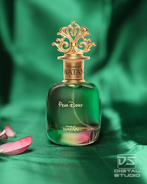 Actual creative product photograph of a dark blue glass perfume bottle styled on a blue fabric studio background.